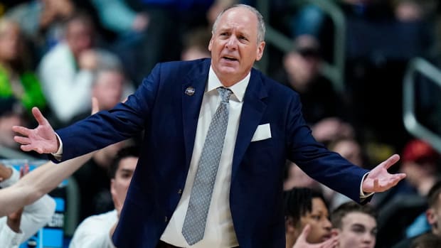 Vermont head coach John Becker questions a call in the first half of a first-round college basketball game against Marquette.